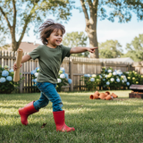 kid pointing and running holding a brown paper scroll in his other hand. outdoors in a typical backyard